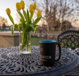 Coffee cup, tulips on patio table
